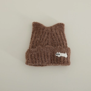 Detail of dark brown plush knit hat with cat ears and a cute white cat patch