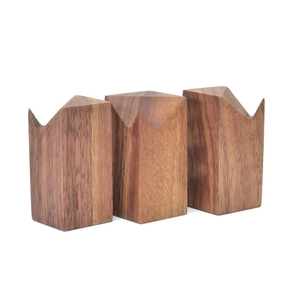 Detailed view of three walnut wood ring displays with unique brass-top grooves on white base