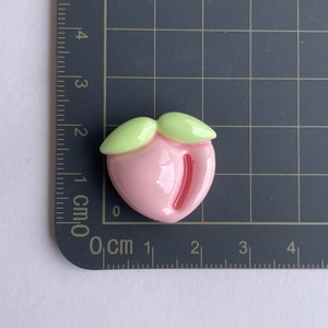 Detailed view of pink resin peach charm on scale mat showing dimensions for DIY crafts