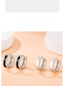 Detail view of monochrome enamel hoop earrings in black and white minimalist finish