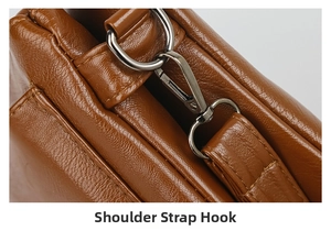 Detail view of silver metal shoulder strap hook on brown litchi pattern leather bag