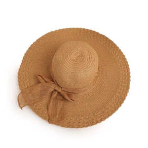 Detailed close-up of woven texture and decorative bow on a brown wide brim sun hat