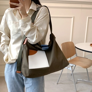 Army green canvas tote bag with contrast panels shown on a model for daily use