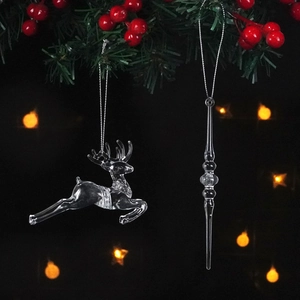Detail of transparent acrylic reindeer and icicle pendants hanging on a Christmas tree