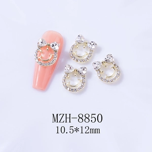 Vue détaillée des bijoux d'ongles sourire doré 10,5x12mm avec zircon sur modèle rose