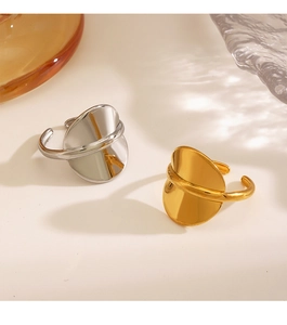 Detailed view of minimalist 18K gold and silver plated fluid geometry rings on a beige background
