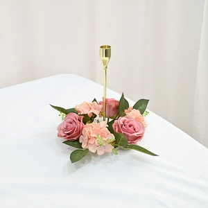 Detail of pink silk roses and hydrangea flowers around a golden metal candlestick stand