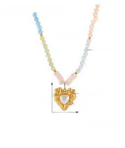 Detail of beaded necklace showing titanium steel gold heart pendant and natural stones