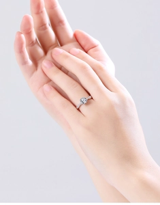 Detail of S925 sterling silver ring featuring a four-prong set moissanite on model hand