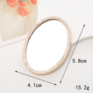 Detailed view of oval golden rhinestone vanity mirror with 5.8cm x 4.1cm measurements