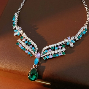 Detailed close-up of vintage flower necklace with a large green teardrop crystal pendant