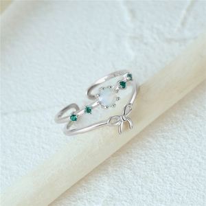 Detail of S925 silver double-layer ring with opal butterfly and green gemstones
