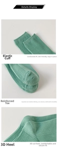 Detail view of green cotton socks showing elastic cuffs, reinforced toes and Y-shape heels