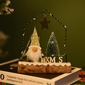 Detail of Christmas gnome and XMAS sign on wood base with LED fairy lights and wire house frame