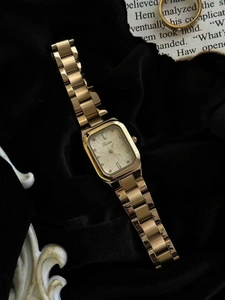 Detail einer eleganten goldenen quadratischen Damenuhr mit Champagner-Zifferblatt auf Samt