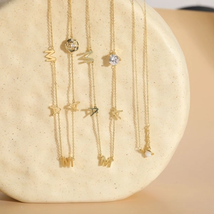 Detailed shot of gold MAMA letter pendants with rose and heart zircon charms