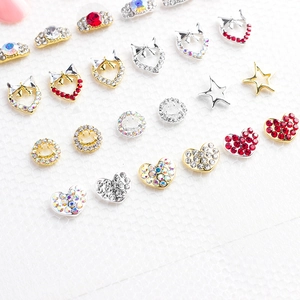 Détail macro de breloques à ongles assorties avec motifs de cœur, d'étoile et de nœud