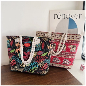 Detail of canvas tote bags with leaf and elephant patterns featuring thick rope handles