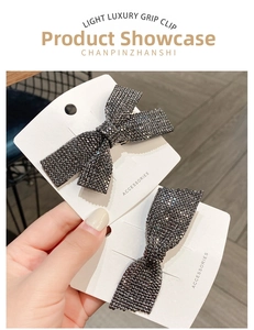 Close-up of sparkling grey rhinestone bow hair clip showing detailed crystal texture
