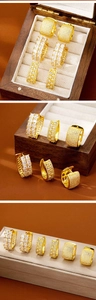 Detailed close-up of three gold geometric huggie earrings with cubic zirconia stones