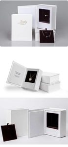 Detail of white book-shaped jewelry box with textured leather and velvet ring holder