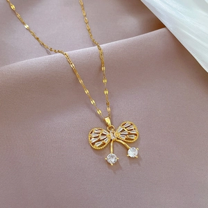 Macro shot of gold butterfly necklace pendant with zircon pavé and hanging chains
