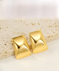 Detail of 18k gold plated rectangular earrings with textured surface on stone
