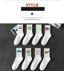 Detail of eight sports crew socks with colorful graffiti letters on a grey mat