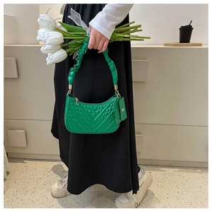 Detail of bright green quilted shoulder bag with V-shaped stitching and mini coin purse