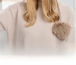 Detailed view of beige knit fabric texture with three soft pom-pom decorations