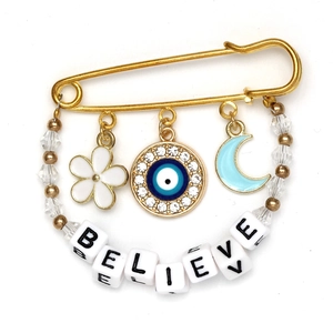 Detail view of Evil Eye brooch with Believe letter beads and crescent moon charm