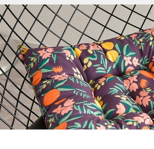 Nahaufnahme von dickem floralen Sitzkissen mit violettem Hintergrund auf Netzstuhl
