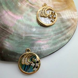 Detailed macro view of 18K gold-plated shell charms with zircon stones and star patterns