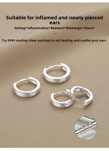 Close-up of S999 sterling silver matte hoop earrings with brushed texture on brown fabric