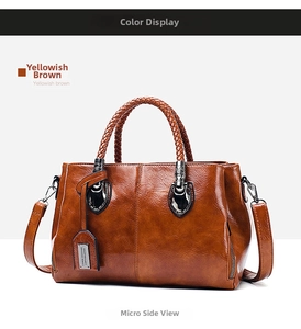 Detail view of yellowish brown oil wax leather Boston bag with woven handles and metal shield buckle