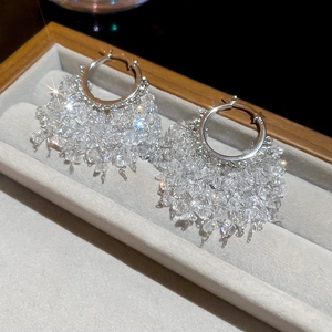Détail macro de boucles d'oreilles franges plaquées or 18 carats avec cristaux brillants