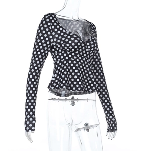 Dettaglio del top a pois sfiancato con scollo a V profondo e bordo a peplo elegante