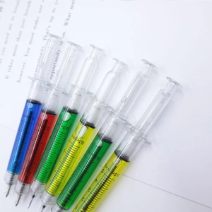 Creative syringe-shaped ballpoint pens in multiple colors on a clean desk