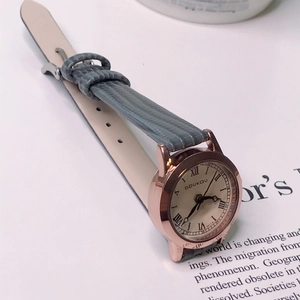 Detail view of the rose gold bezel and grey-blue leather strap of this elegant ladies' watch