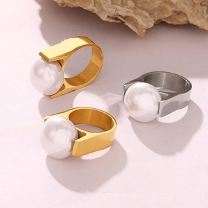 Three minimalist wide band rings in gold and silver with oversized white pearls