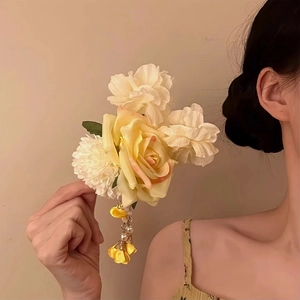 Elegant fabric flower hair clip with pearls and long tassel worn on model's head