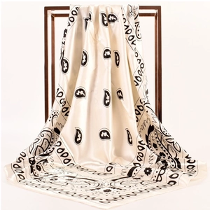 Detail of elegant paisley print on beige satin silk square scarf with soft fabric drape