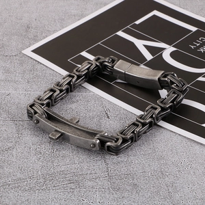Macro view of vintage industrial stainless steel cross bracelet on stone background