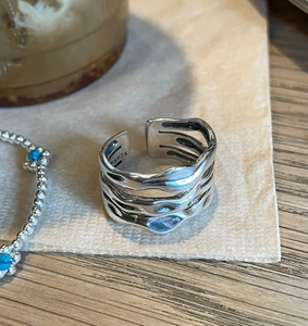 Macro detail of multi-layered S925 sterling silver ring with liquid metal wave texture