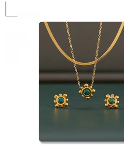 Detail view of gold layered necklace and matching green gemstone stud earrings set