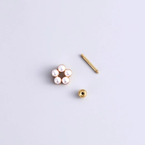 Detailed view of disassembled gold flower earring with pearls and threaded screw back