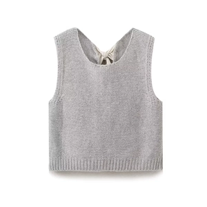 Détail d'un gilet sans manches en tricot gris avec un nœud en soie crème au col arrière