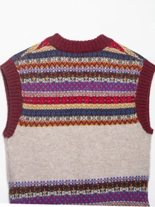 Detail of multi-color jacquard knit vest with ethnic geometric patterns and ribbed burgundy trim