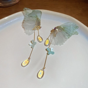 Detail of butterfly drop earrings with gradient green wings and crystal teardrop pendants