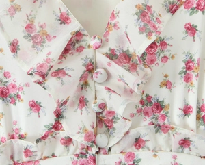 Close-up of floral chiffon dress V-neck with layered ruffles and matching fabric buttons